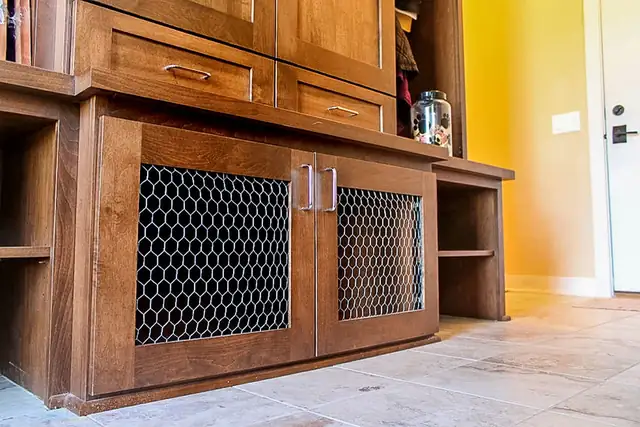 Built-in pet room in Madison, WI with wood cabinetry and chicken-wire kennel doors