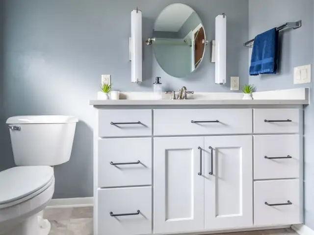 Aging-in-place bathroom in Brooklyn, WI with white shaker vanity, round mirror and soft gray walls