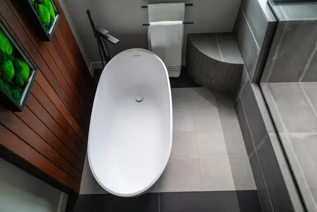 Madison, WI bathroom remodel with an oval soaking tub, dark wood wall slats and a tiled steam shower bench