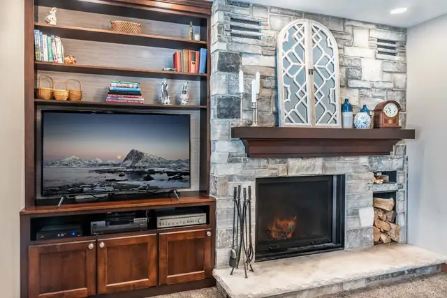 Sun Prairie, WI family room remodel with a stacked stone fireplace, wood mantel and built-in media cabinets