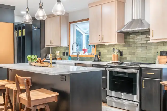 Madison kitchen by Degnan with natural maple uppers, dark lower cabinets, a green tile backsplash and glass pendants